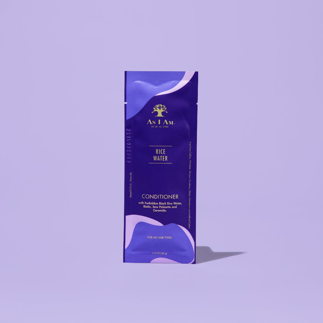 AS I AM Acondicionador de Agua de Arroz en una bolsita de 1 oz, con una textura cremosa y rica con un acabado blanco nacarado, formulado para hidratar en profundidad, fortalecer y desenredar el cabello con textura, al tiempo que promueve el crecimiento del cabello, previene la caída y combate la rotura del cabello.