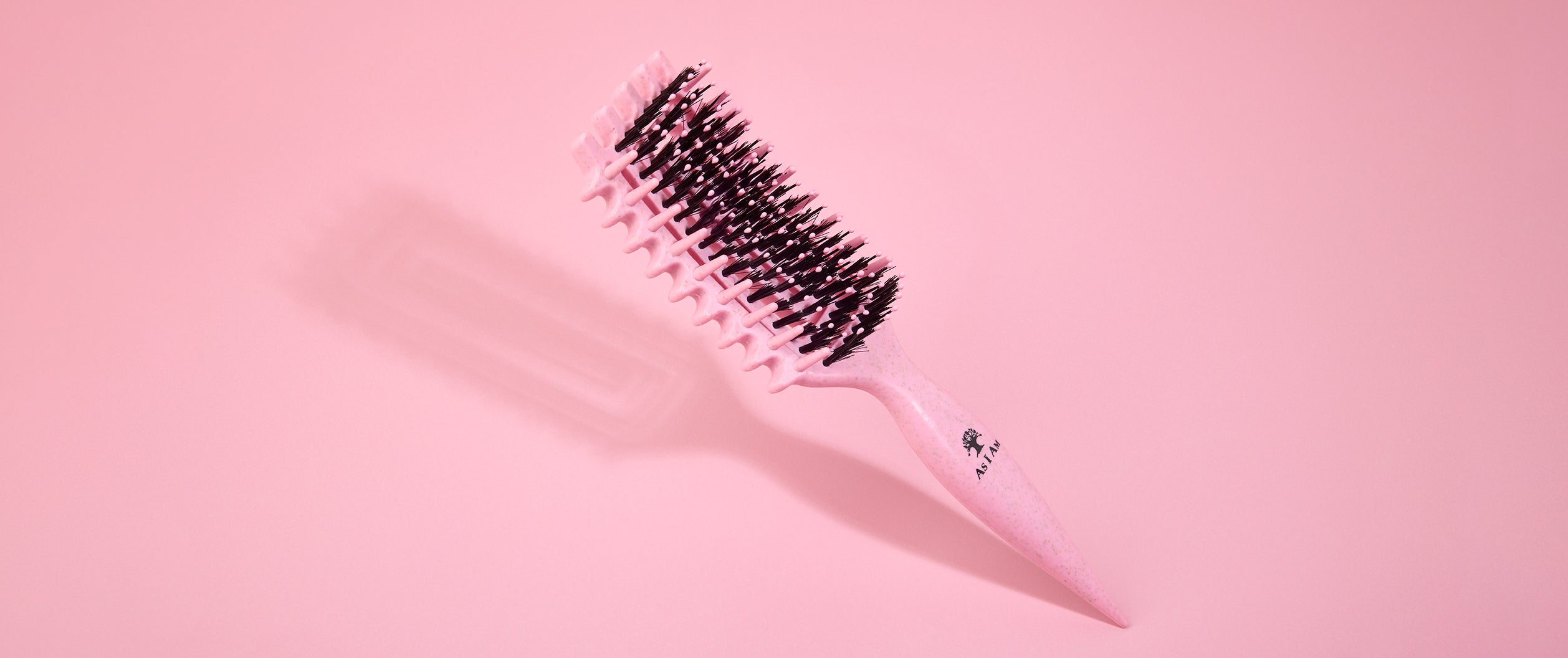 Cepillo para el pelo sobre fondo rosa