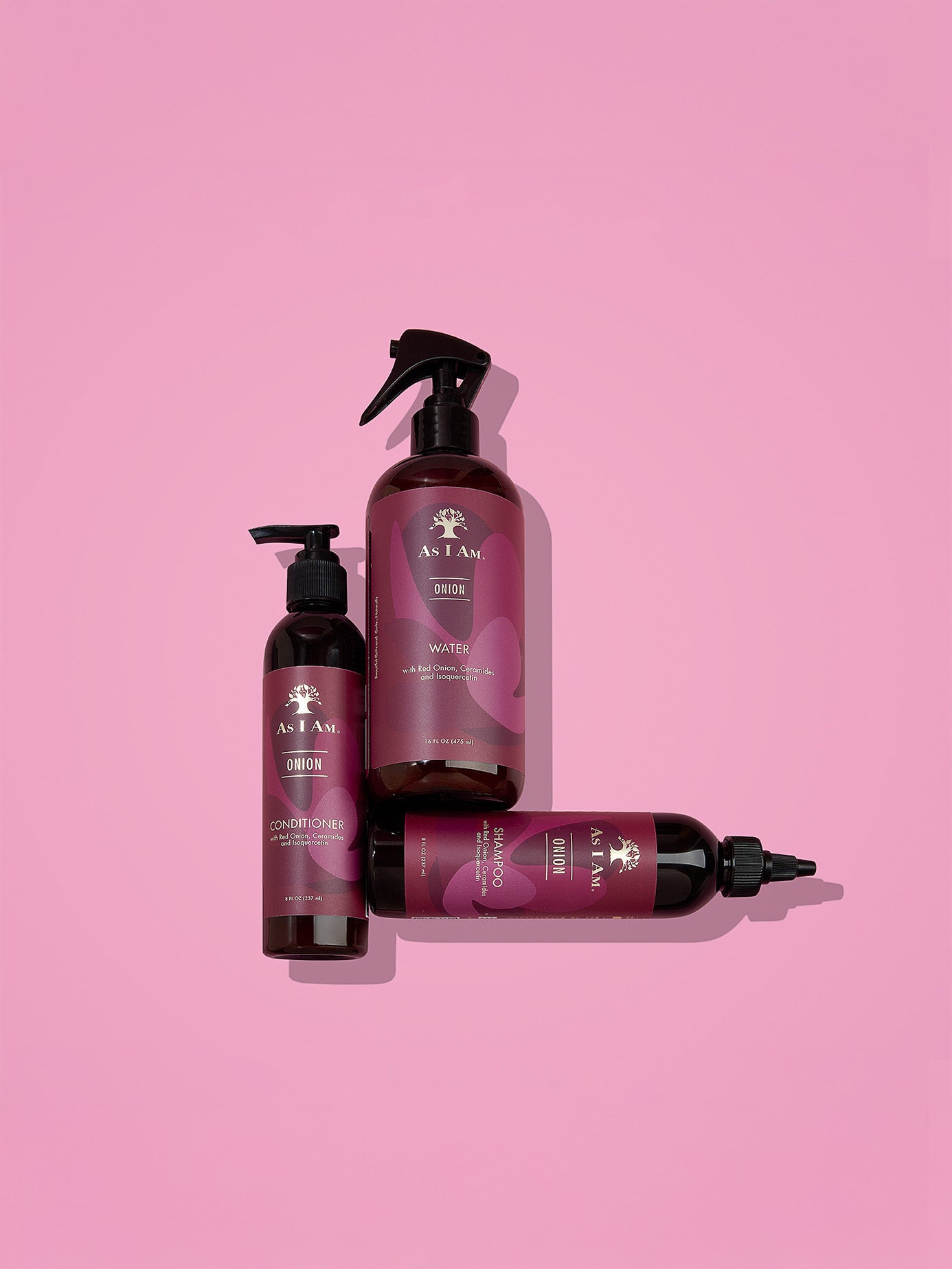 Conjunto de productos para el cuidado del cabello con la marca visible sobre fondo rosa.