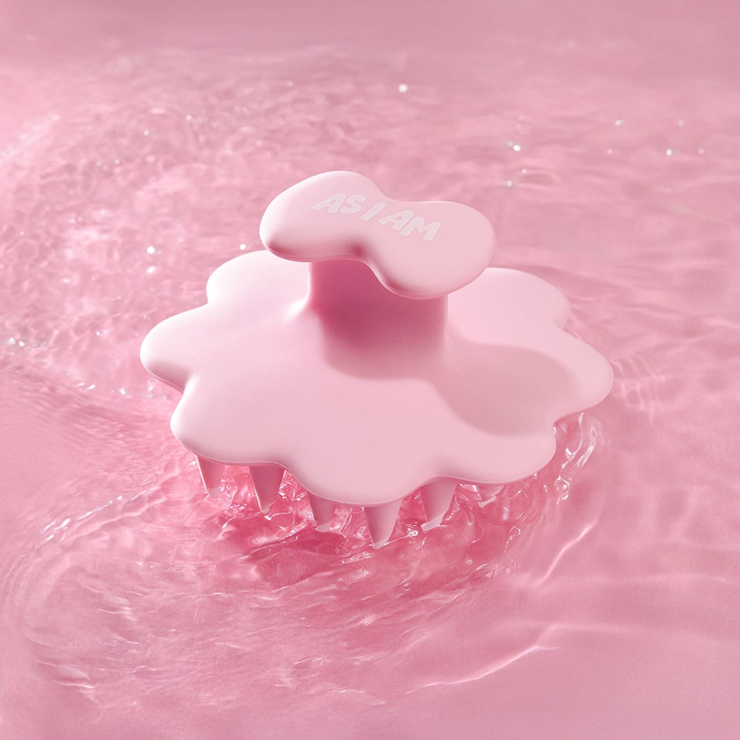 Cepillo de cuero cabelludo rosa sobre un fondo de agua rosa