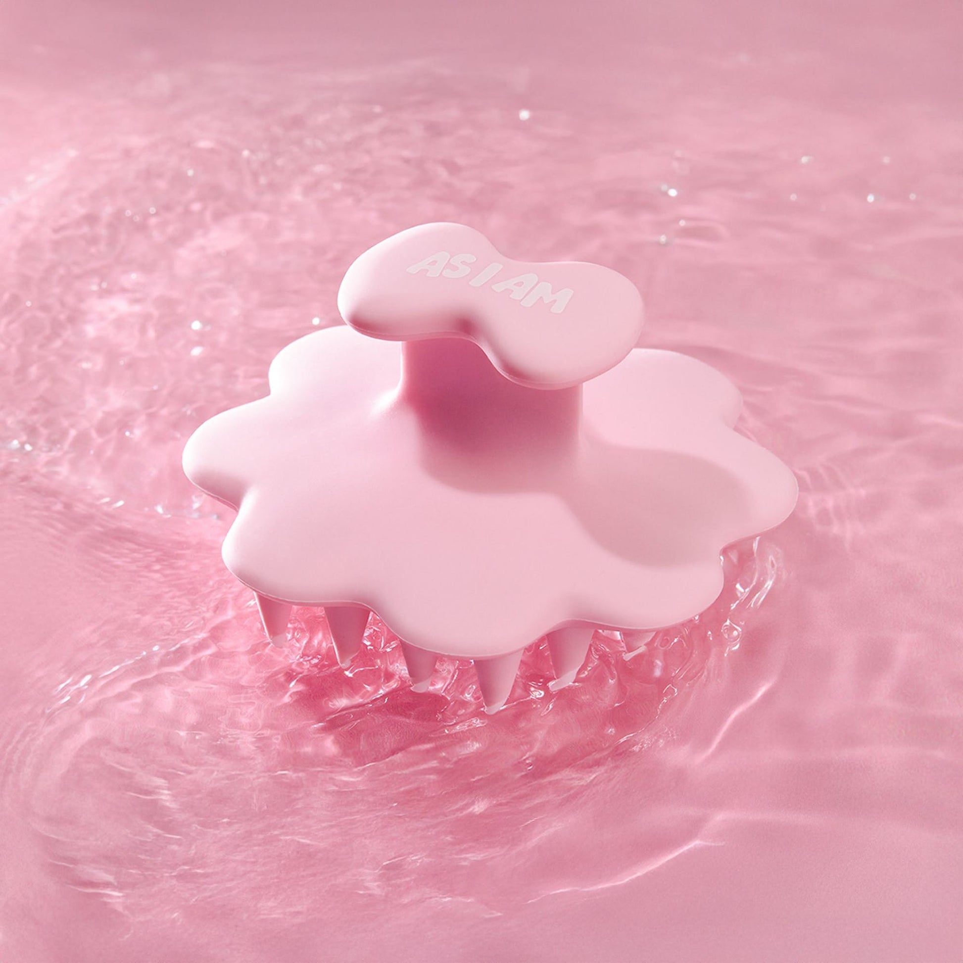 Cepillo de cuero cabelludo rosa sobre un fondo de agua rosa