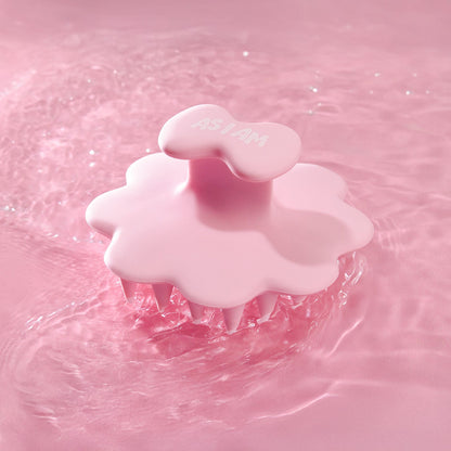 Cepillo de cuero cabelludo rosa sobre un fondo de agua rosa