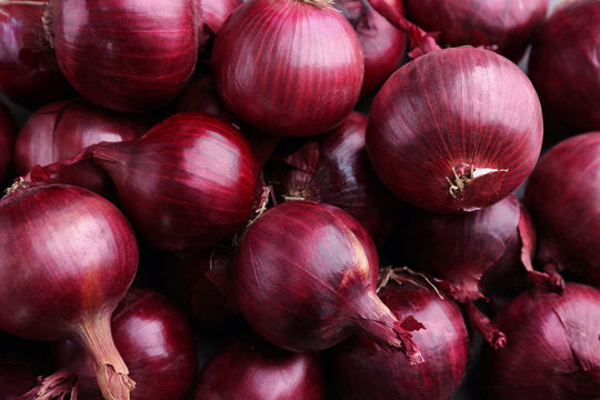Primer plano de cebollas rojas con fondo oscuro