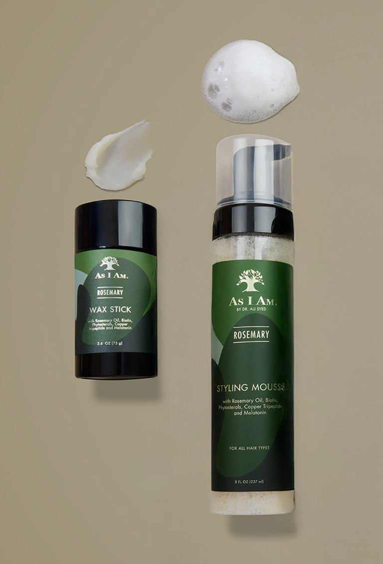 Productos para el cuidado del cabello As I Am, incluyendo una barra de cera y una espuma moldeadora sobre un fondo beige.