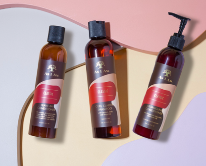 Tres botellas de productos para el cuidado del cabello Aji Amor sobre un fondo colorido.